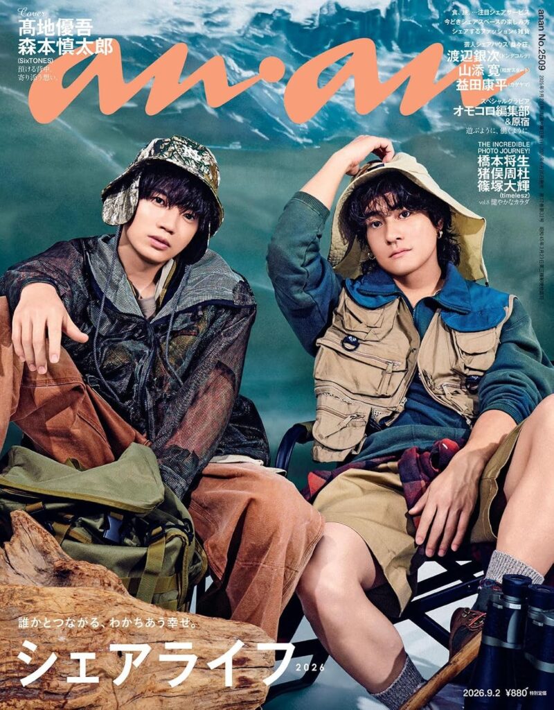 Two young men in hiking outfits sit on a log by turquoise water, with a bold orange magazine title across the top. (Magazine cover)